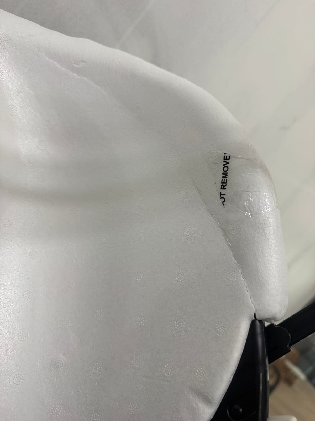 Cracked corner of car seat foam held together with clear tape